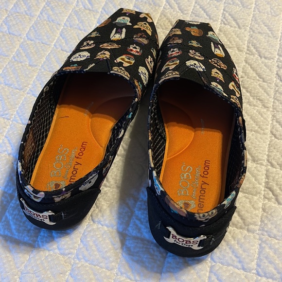 BOBS By Skechers slip on shoes in black with various dog designs on the shoes. - Picture 2 of 8